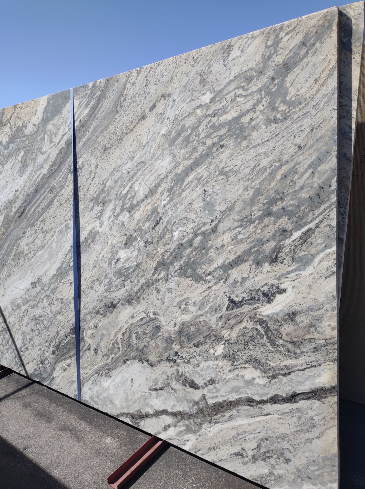 A large slab of marble is sitting on top of a concrete surface.
