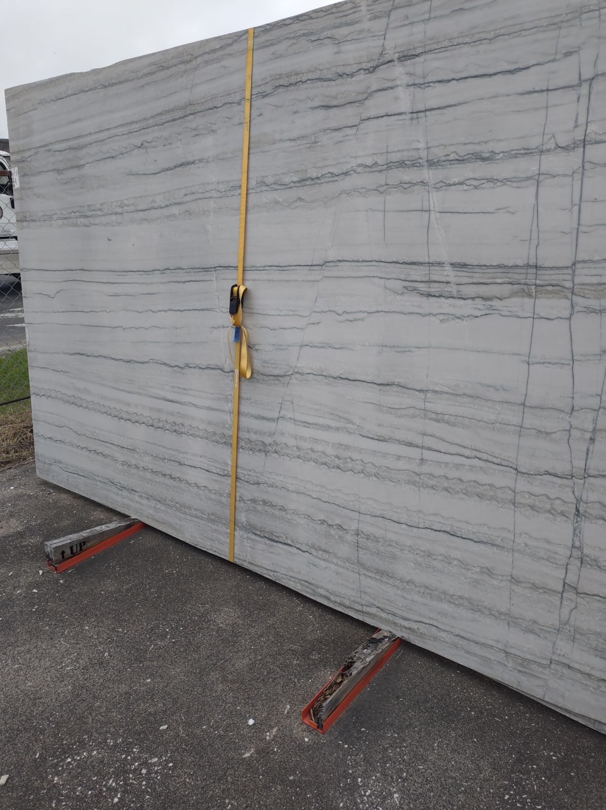 A large white marble slab is sitting on top of a concrete surface.