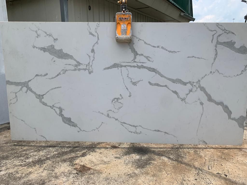 A large slab of marble is being lifted by a crane.