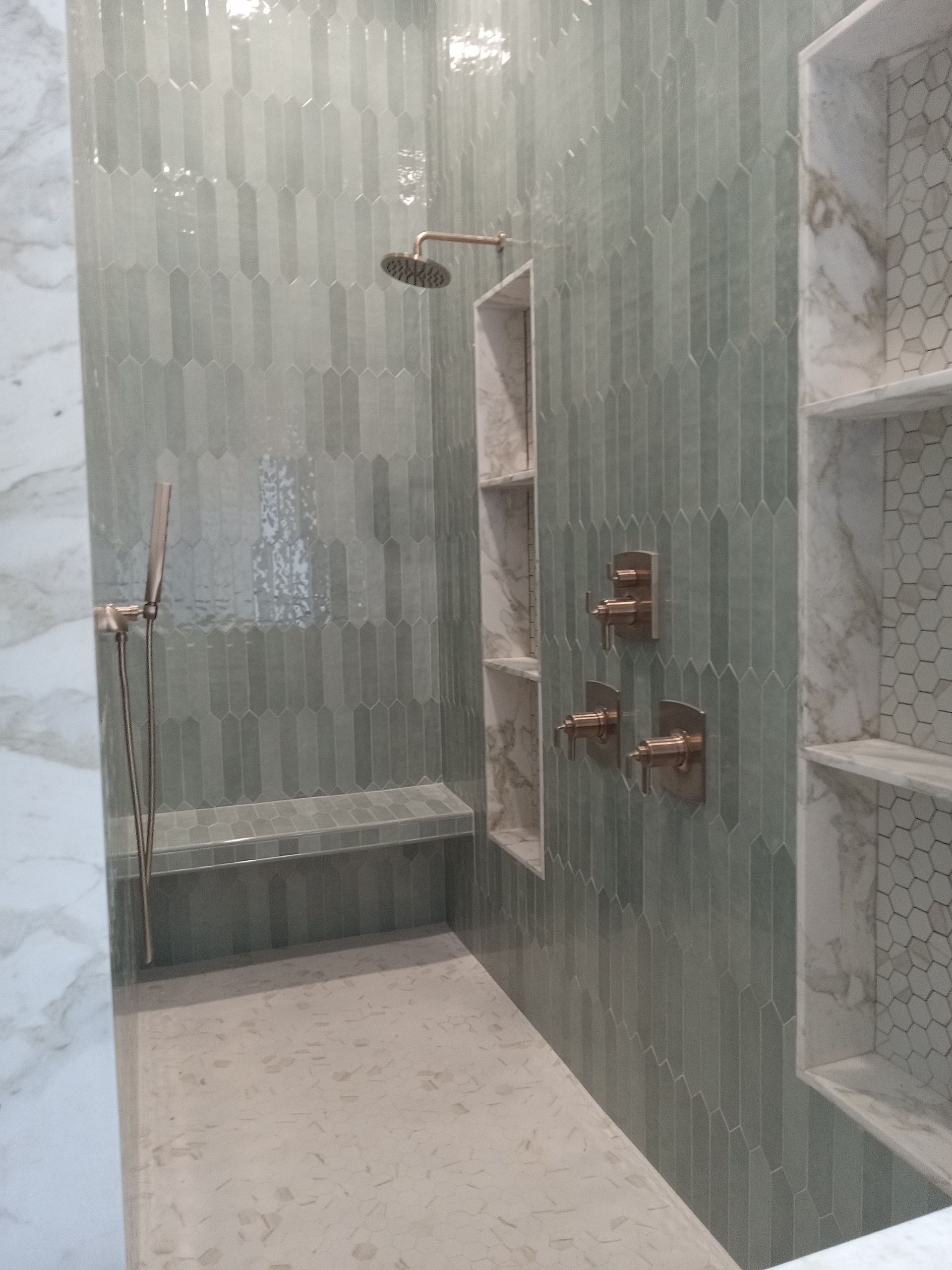 A bathroom with a walk in shower and a bench.