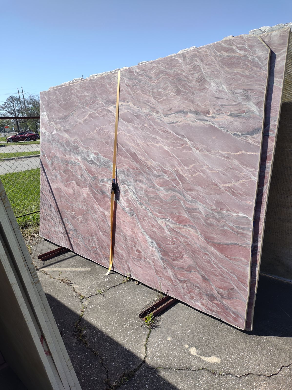 A large pink granite slab is sitting on top of a concrete surface.