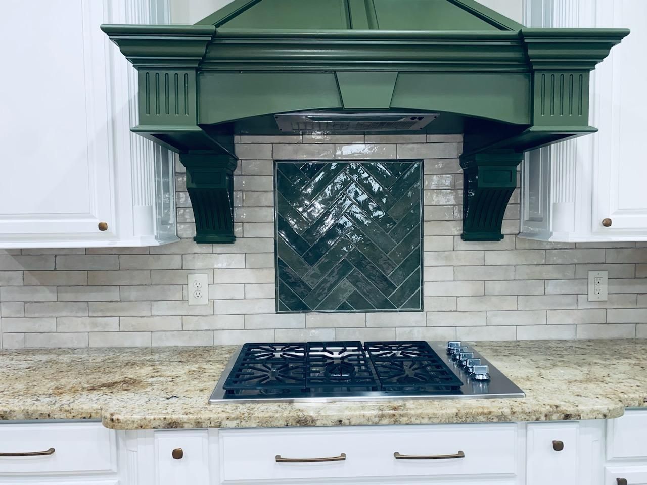 A kitchen with a stove top oven and a green hood