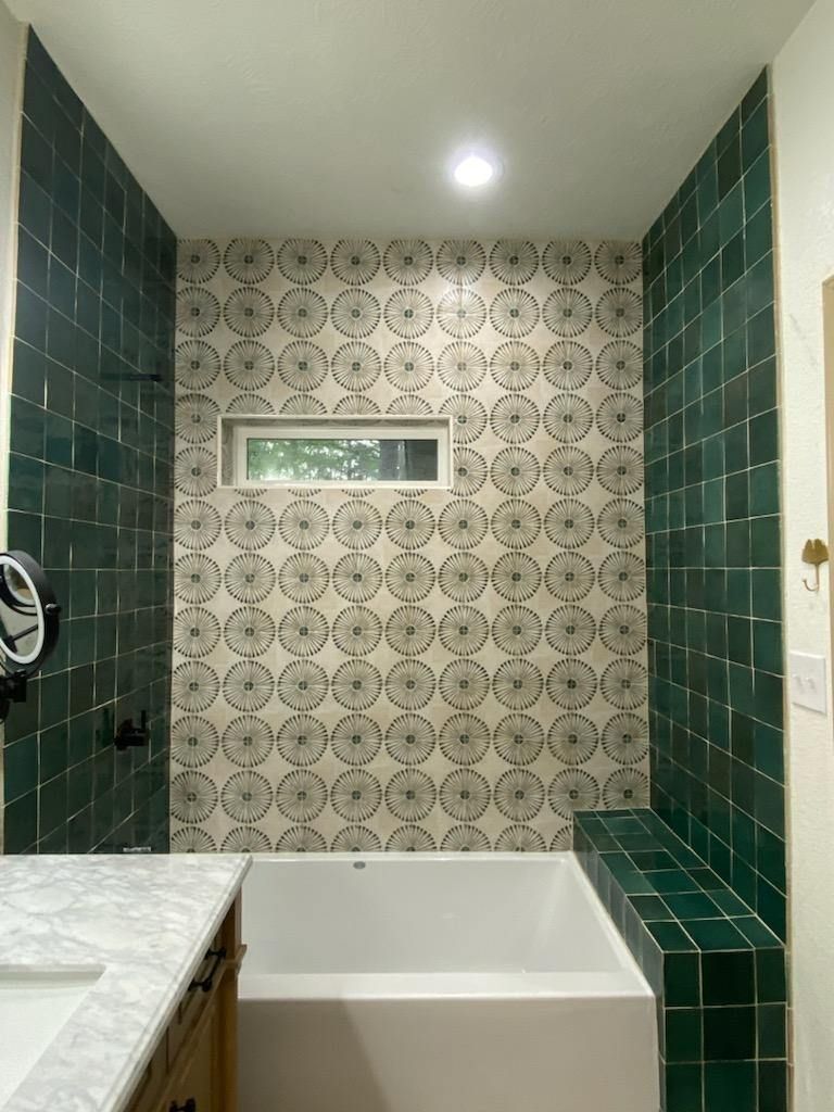 A bathroom with green tiles and a bathtub.