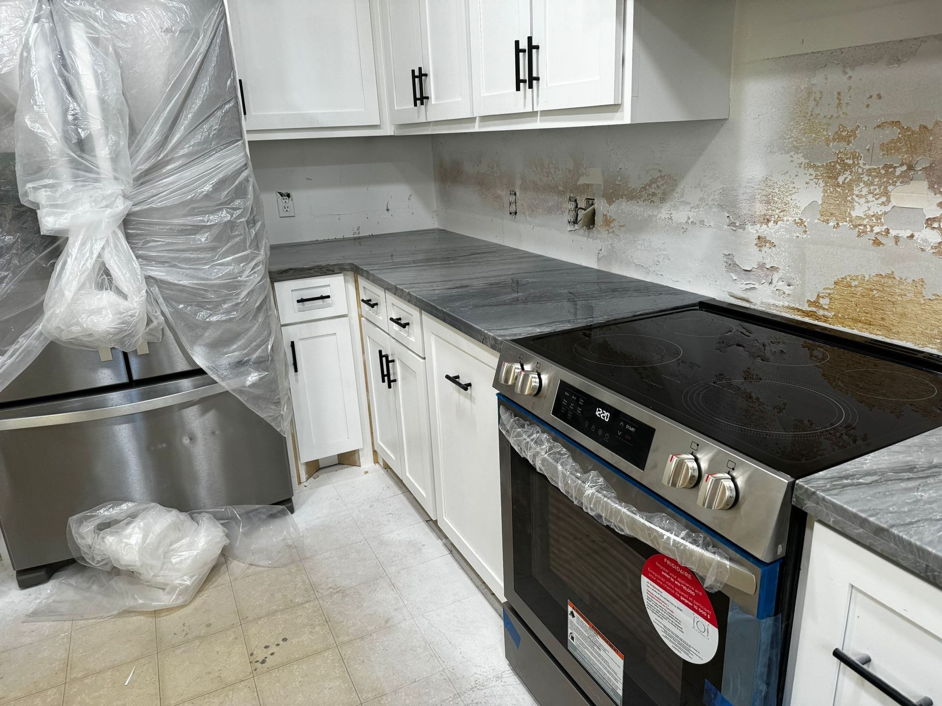 A kitchen with stainless steel appliances and white cabinets