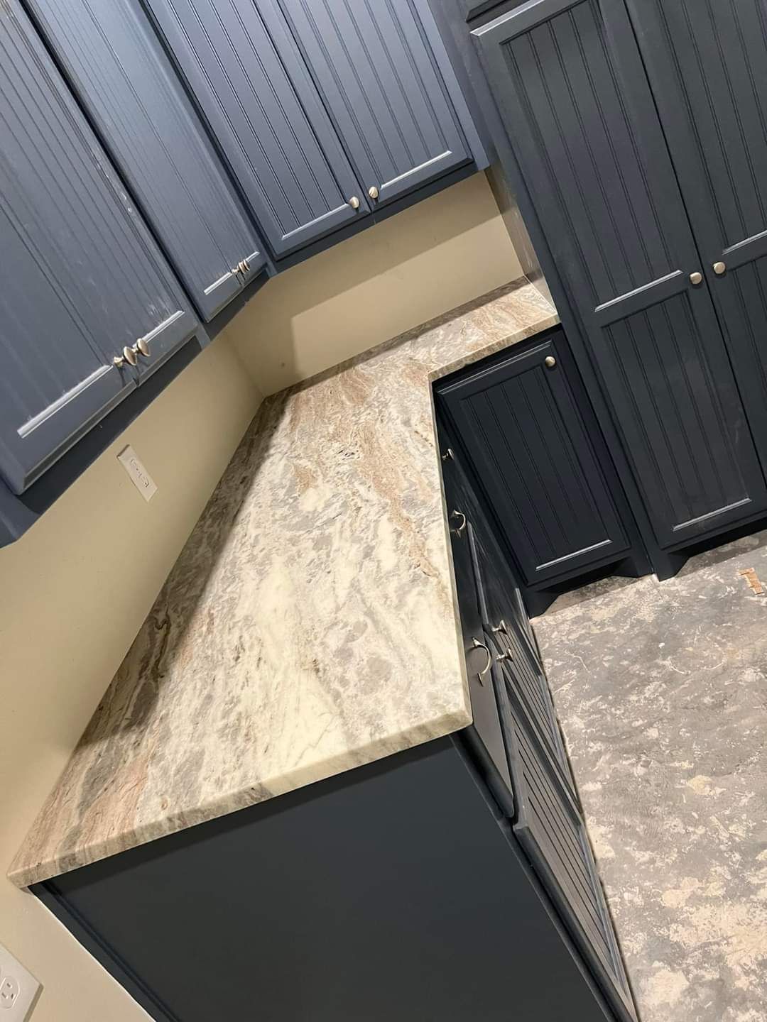 A kitchen with blue cabinets and a granite counter top.