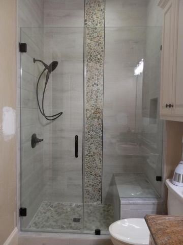 A bathroom with a walk in shower and a sink.