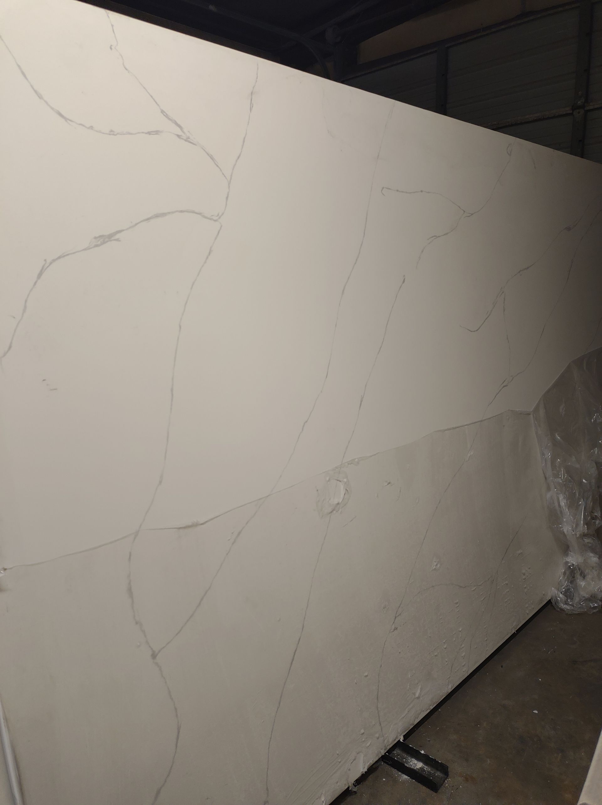 A large piece of white marble is sitting on the floor.