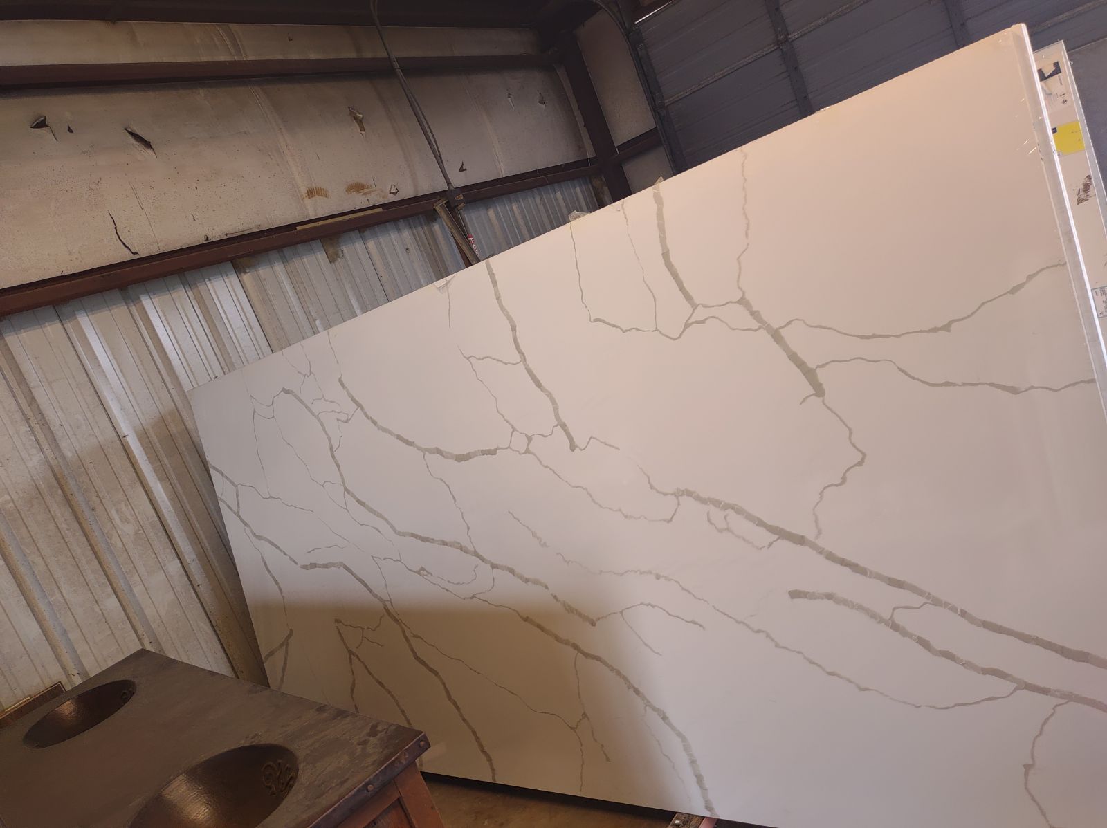 A large white slab of marble is sitting in a warehouse.
