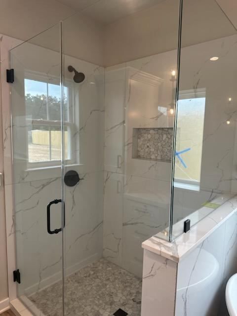 A bathroom with a walk in shower and a window