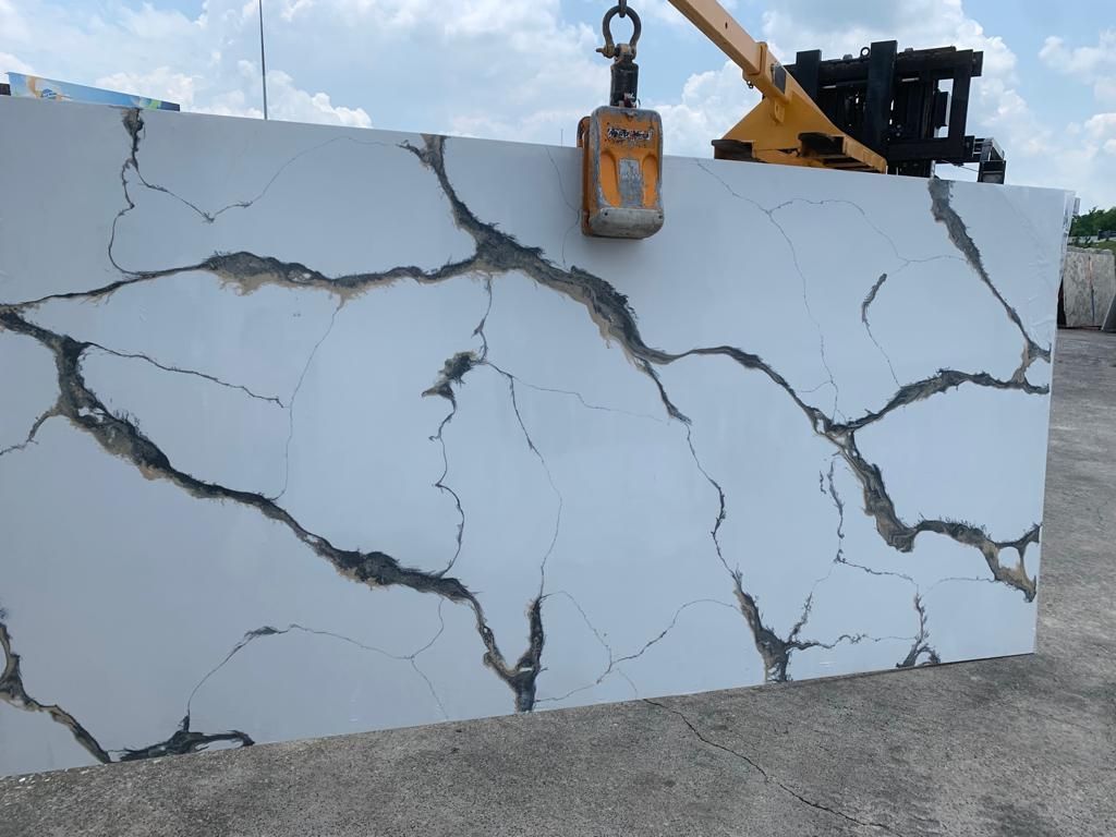 A large piece of marble is being lifted by a crane.