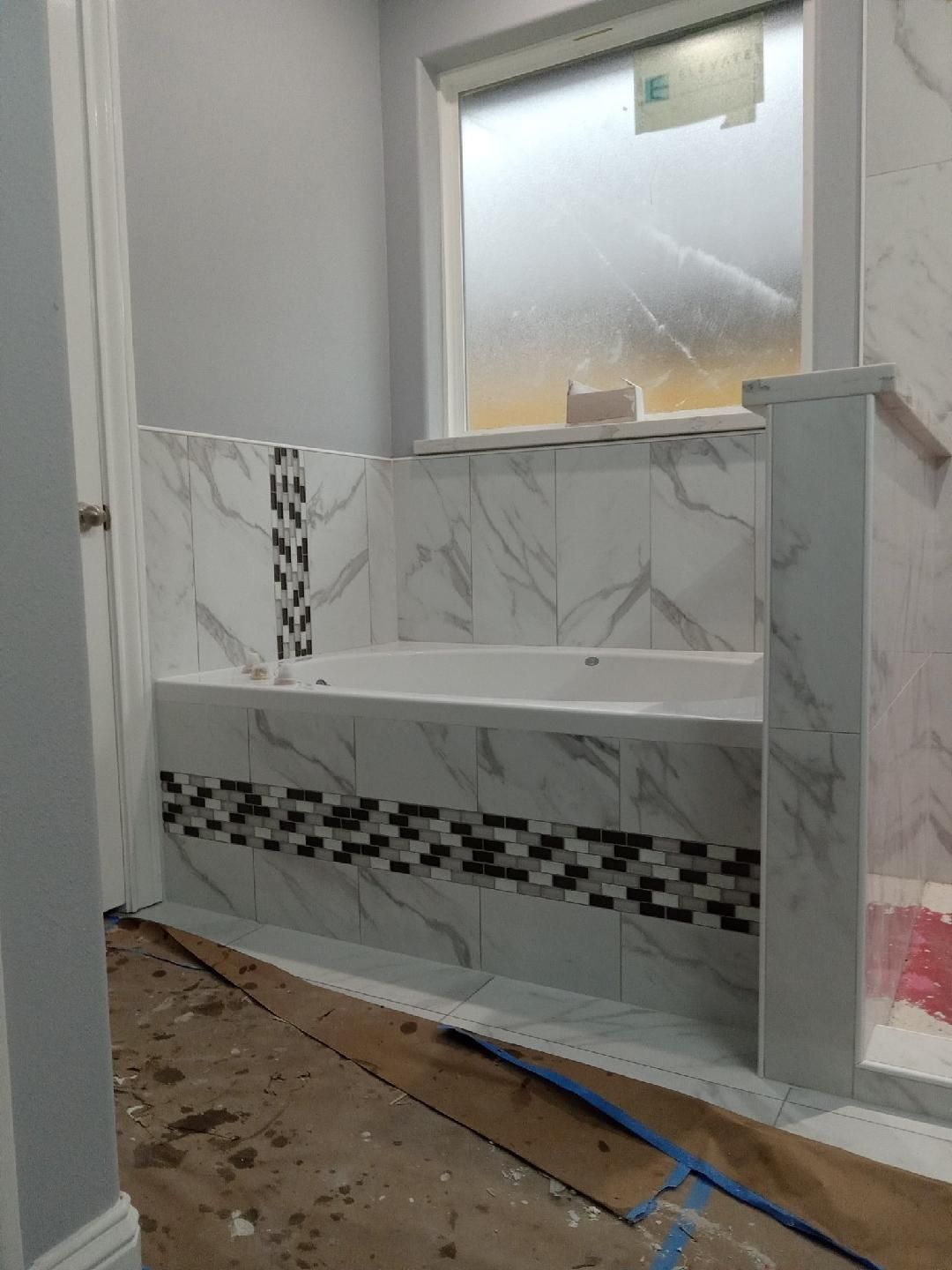 A bathroom with a bathtub and a window.