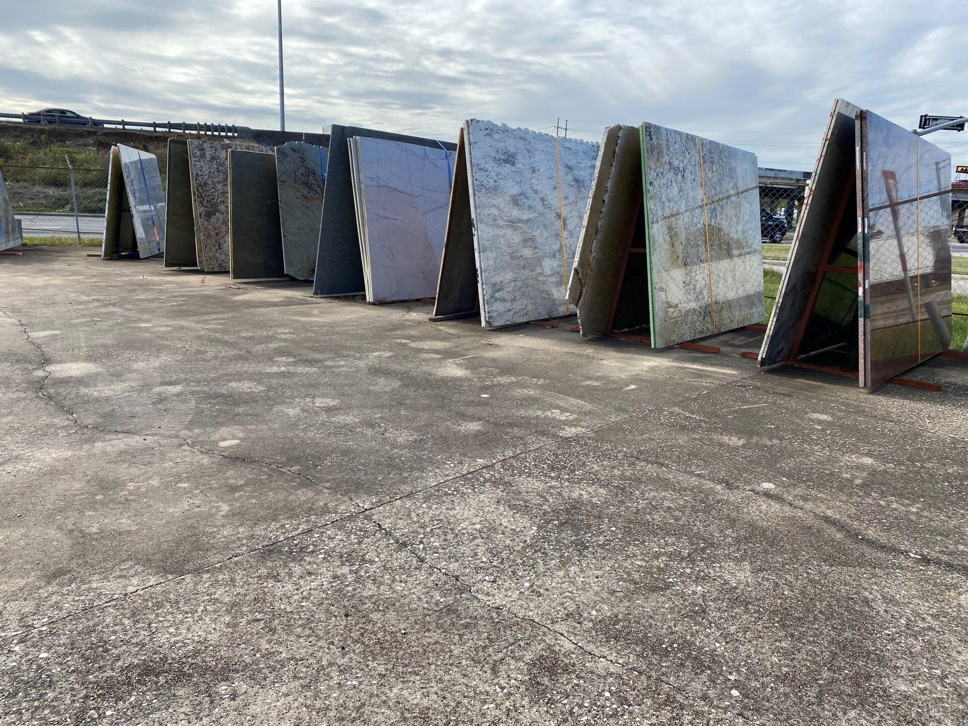 A row of marble slabs are lined up in a parking lot.