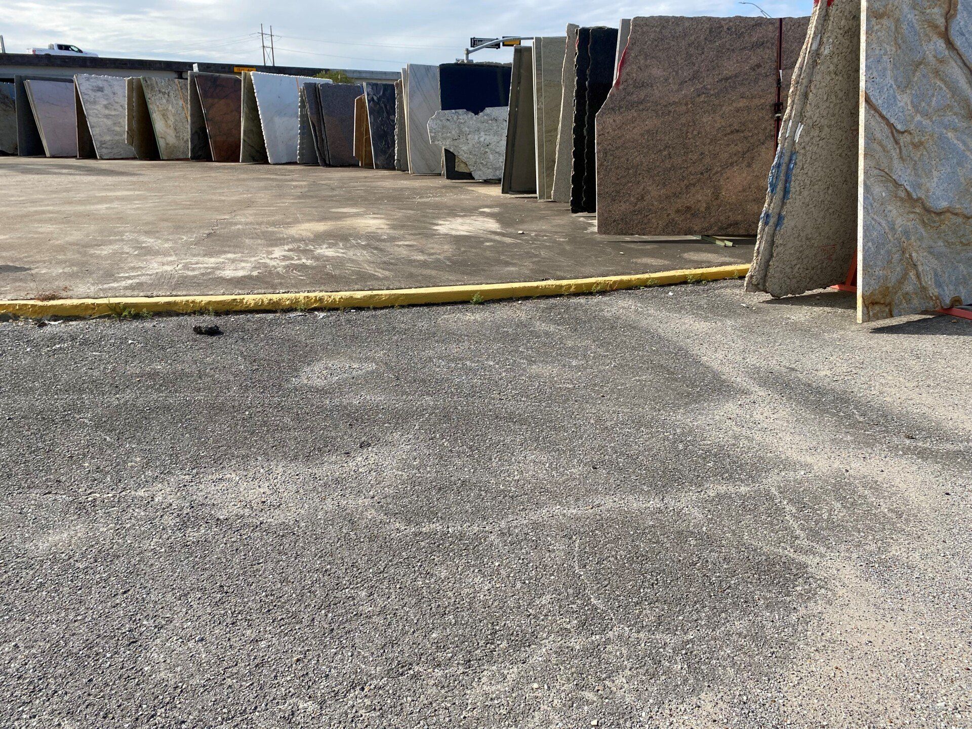 A row of marble slabs are lined up in a parking lot.