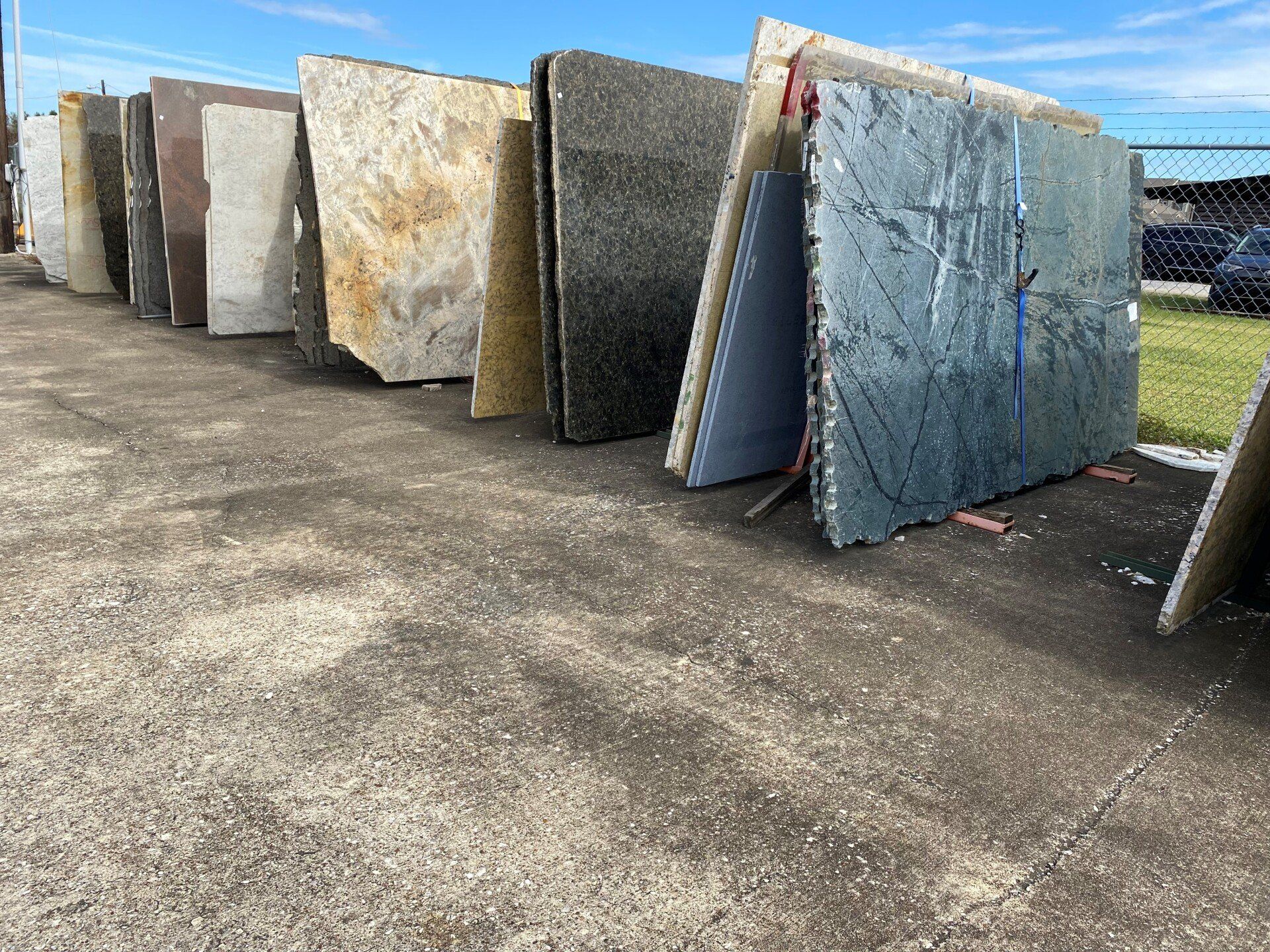A row of granite slabs are stacked on top of each other in a parking lot.