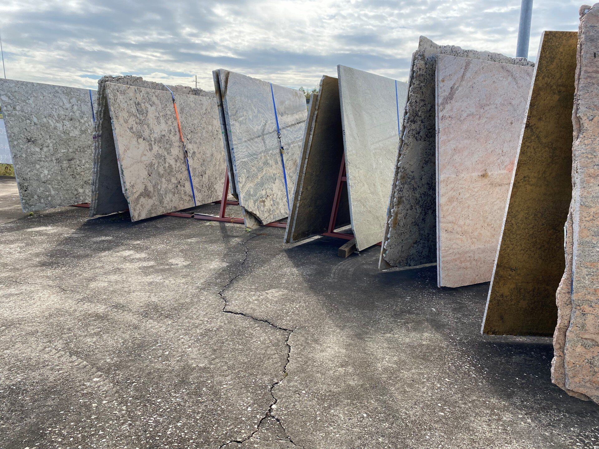 A row of granite slabs are stacked on top of each other in a parking lot.