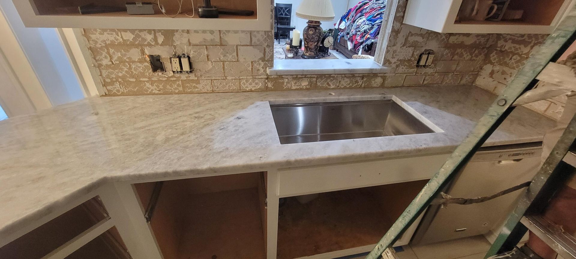 A kitchen with a stainless steel sink and a window.