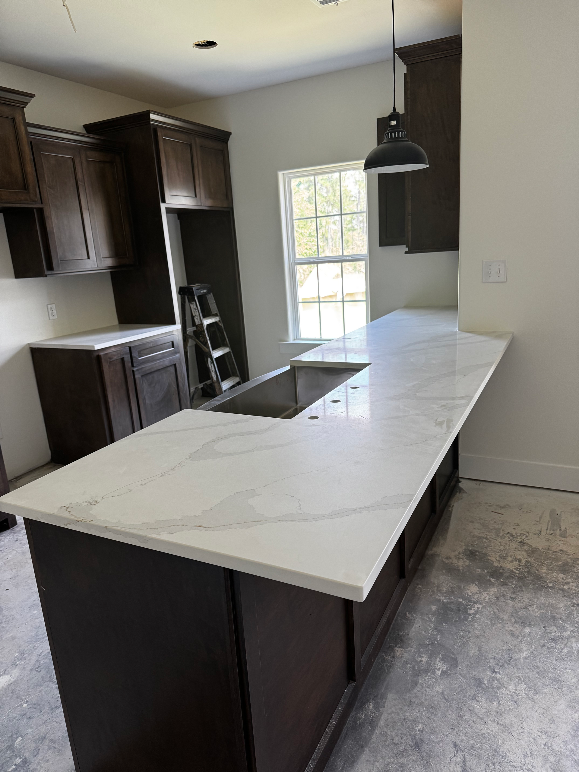 A kitchen with a large island and a sink.