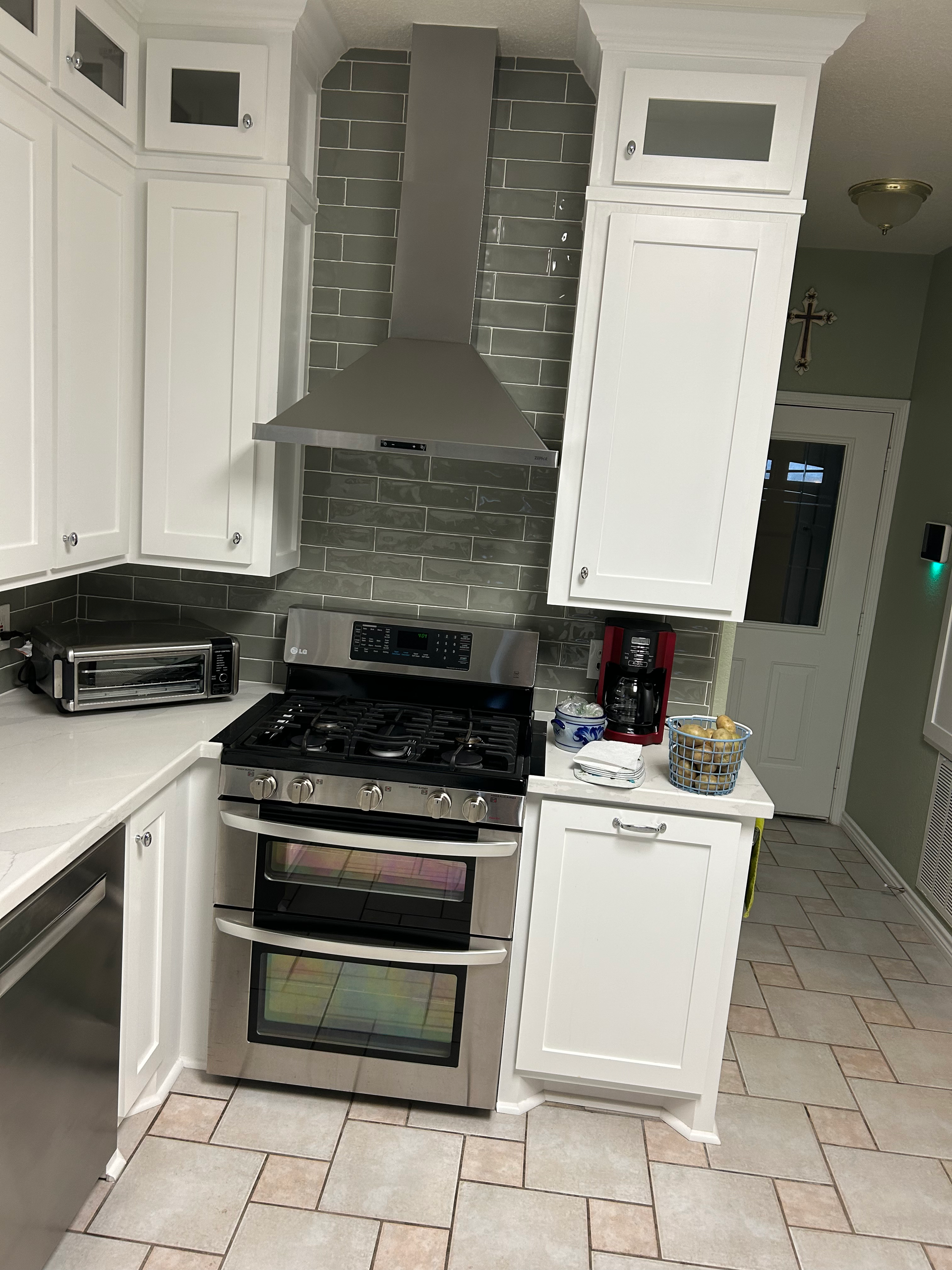 A kitchen with stainless steel appliances and white cabinets