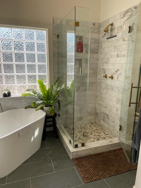 A bathroom with a bathtub and a walk in shower.