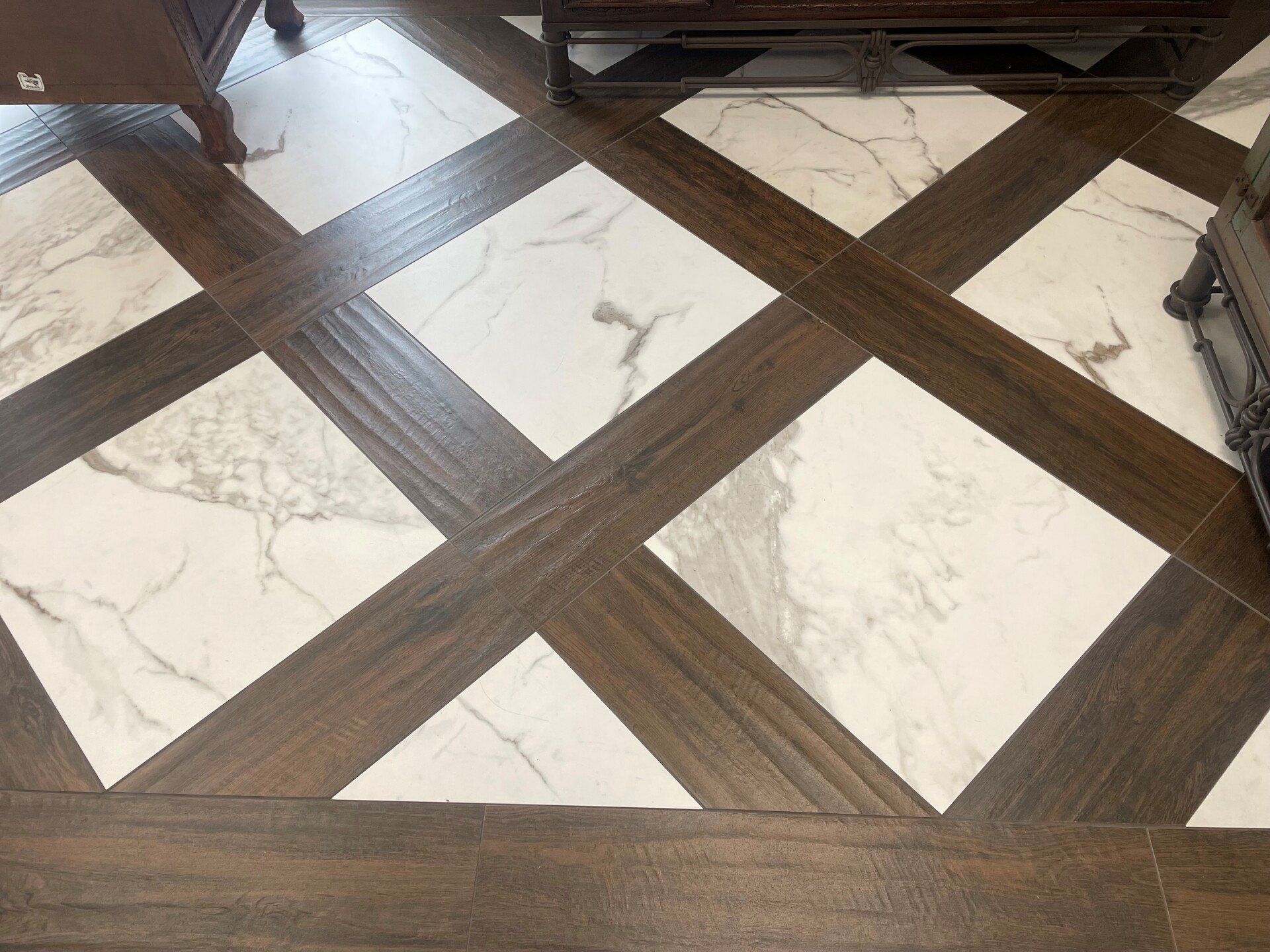 A wooden floor with marble tiles in a living room.
