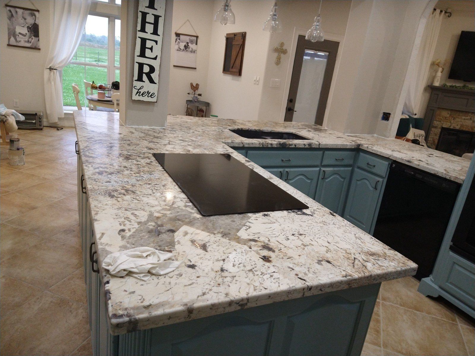 A kitchen with a large island and a stove top oven.