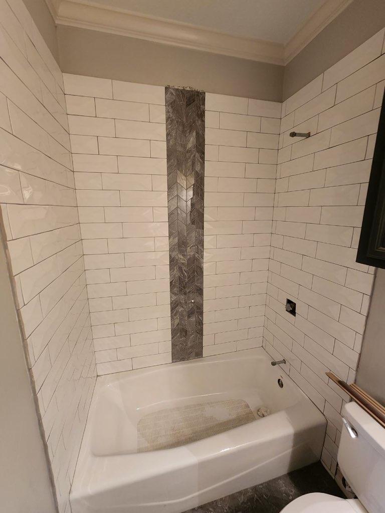 A bathroom with a tub , toilet and shower.