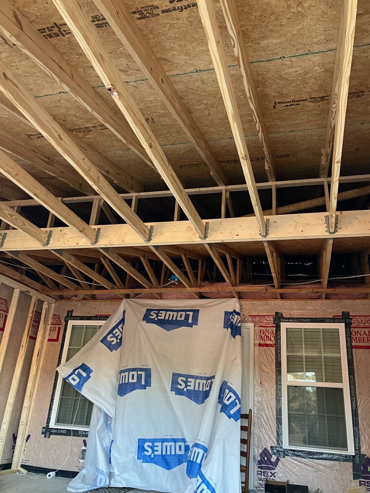 A house is being built with a lot of wood and a lot of windows.
