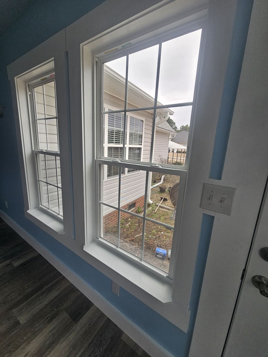 A room with three windows and a blue wall.