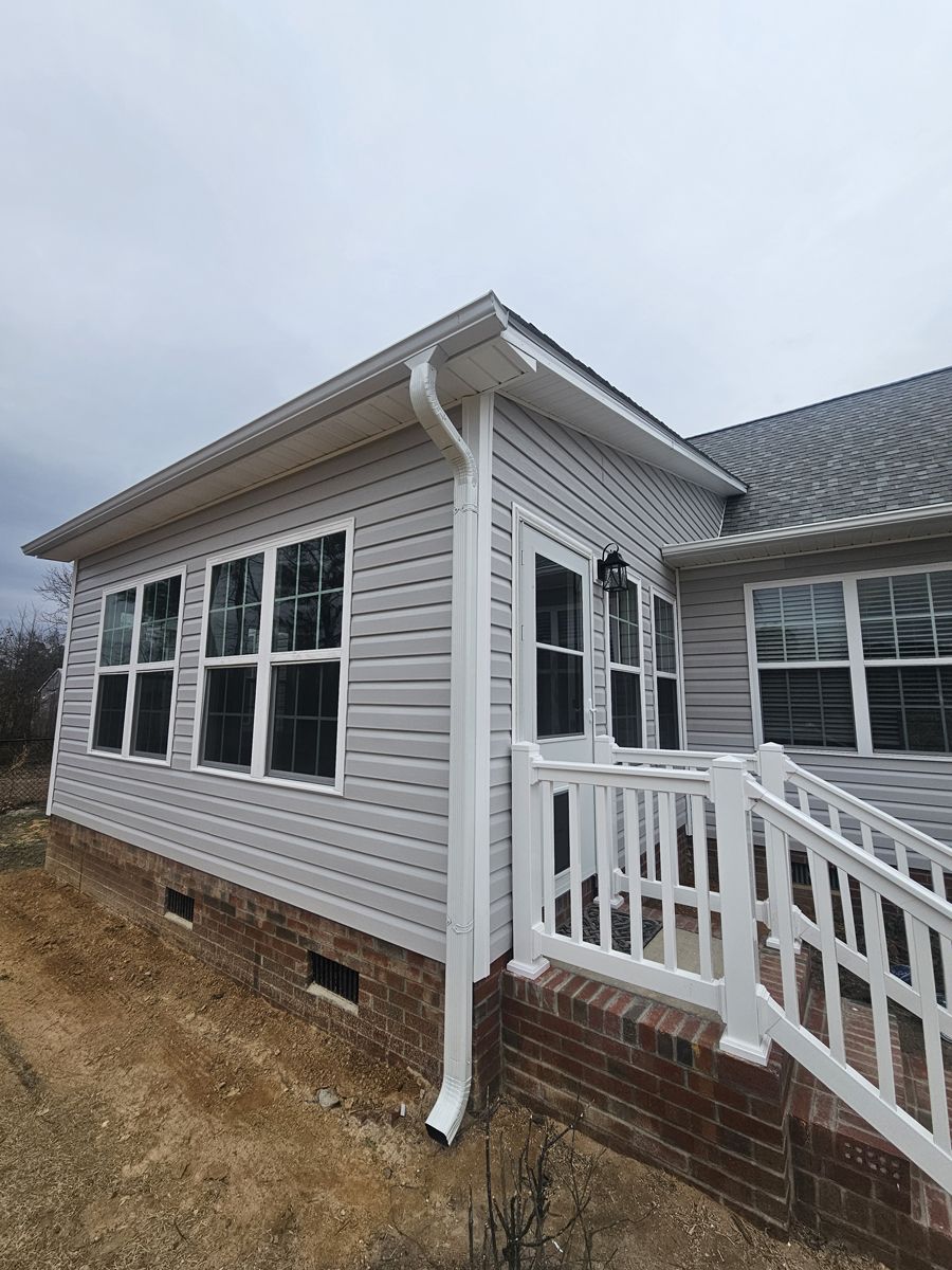 A house with a white fence and stairs leading to it.