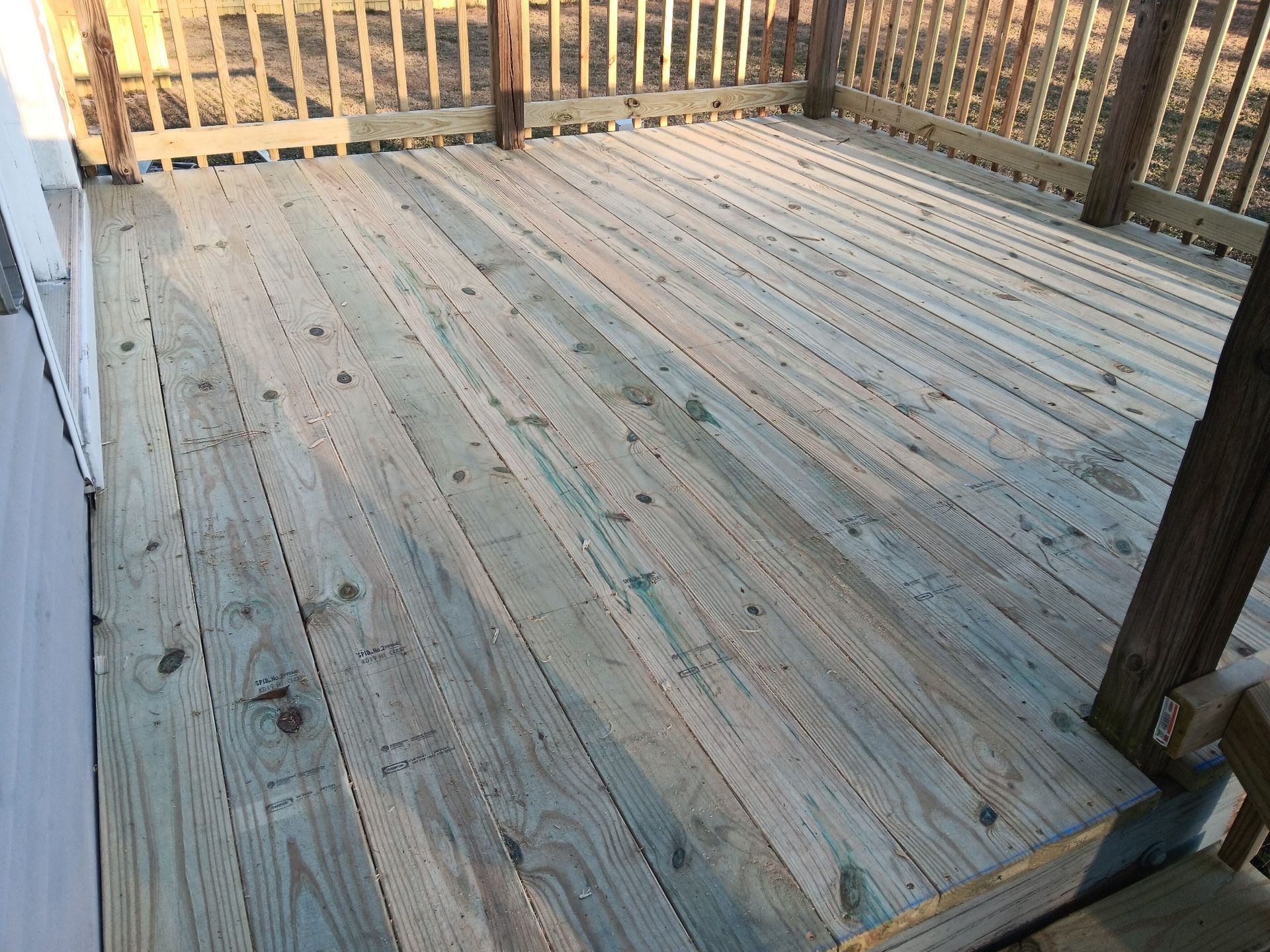 A wooden deck with a fence in the background.