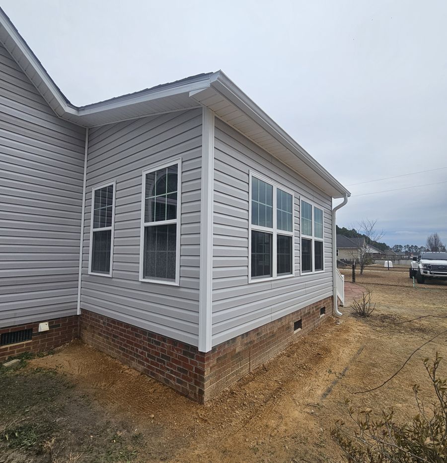 A white house with a lot of windows and a truck parked in front of it.
