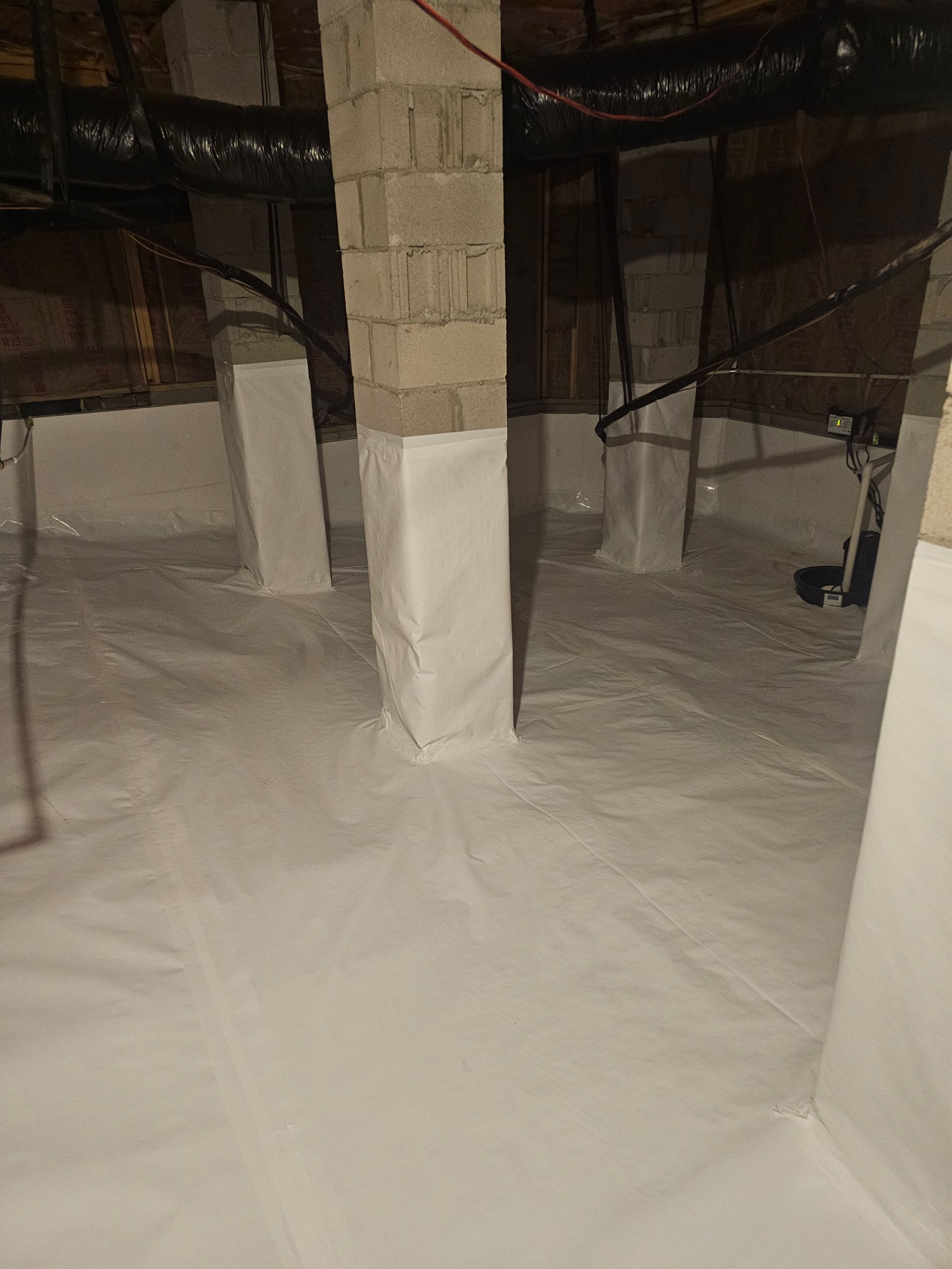 A basement filled with white plastic and brick pillars.