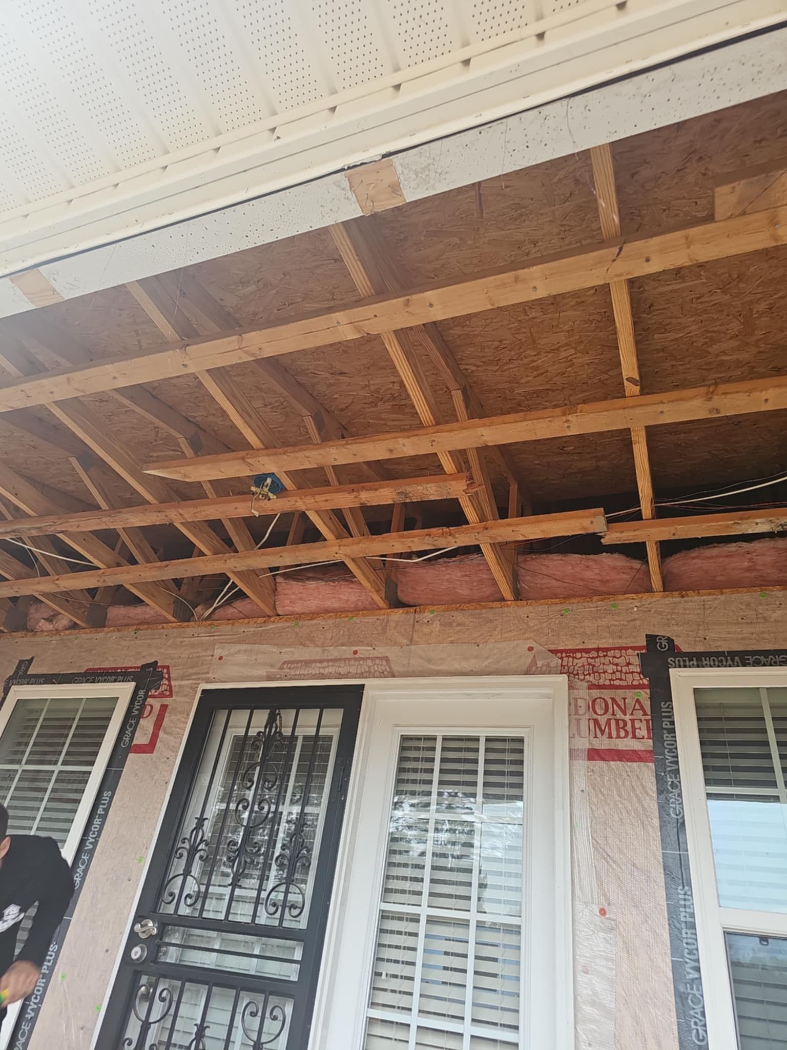 A man is working on the ceiling of a house under construction.