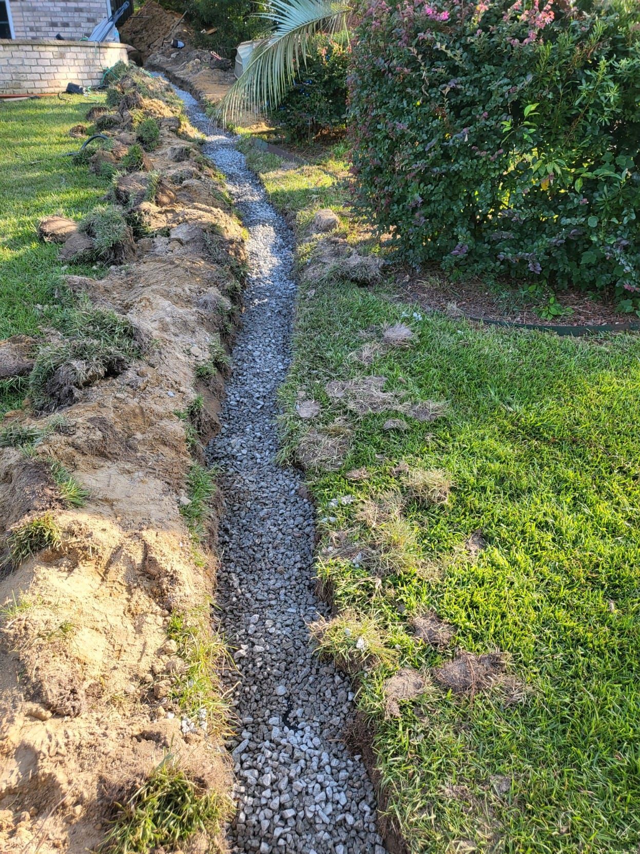 A drainage system is being installed in a yard.