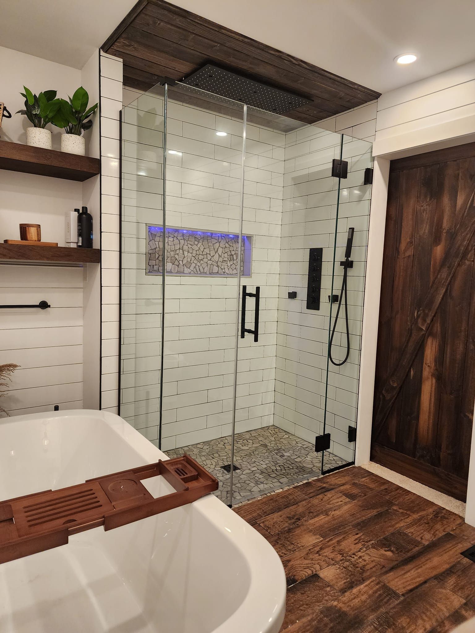 A bathroom with a bathtub and a walk in shower.