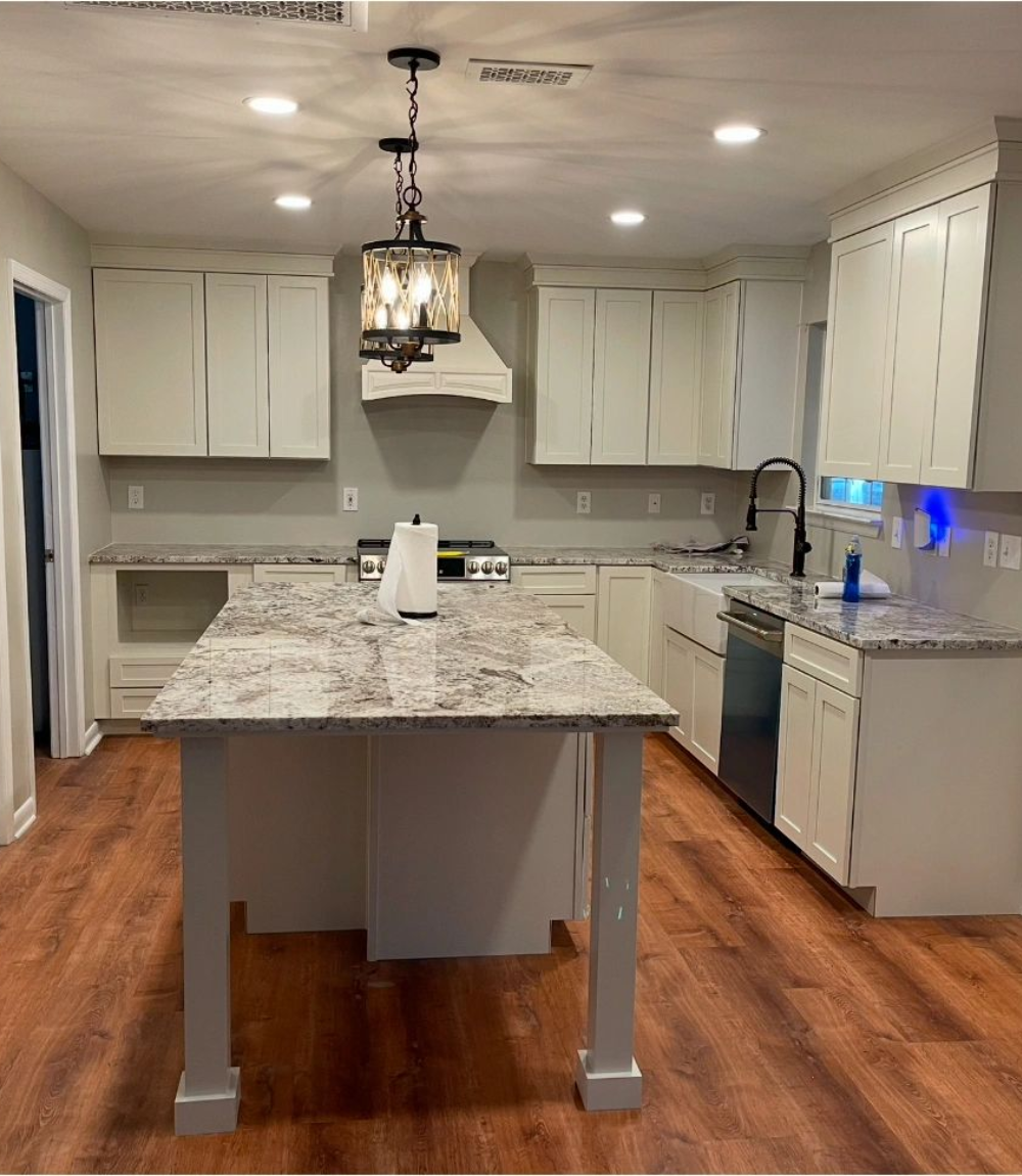 A newly remodeled kitchen with light cabinetry, granite countertops, a central island, and wood floors.