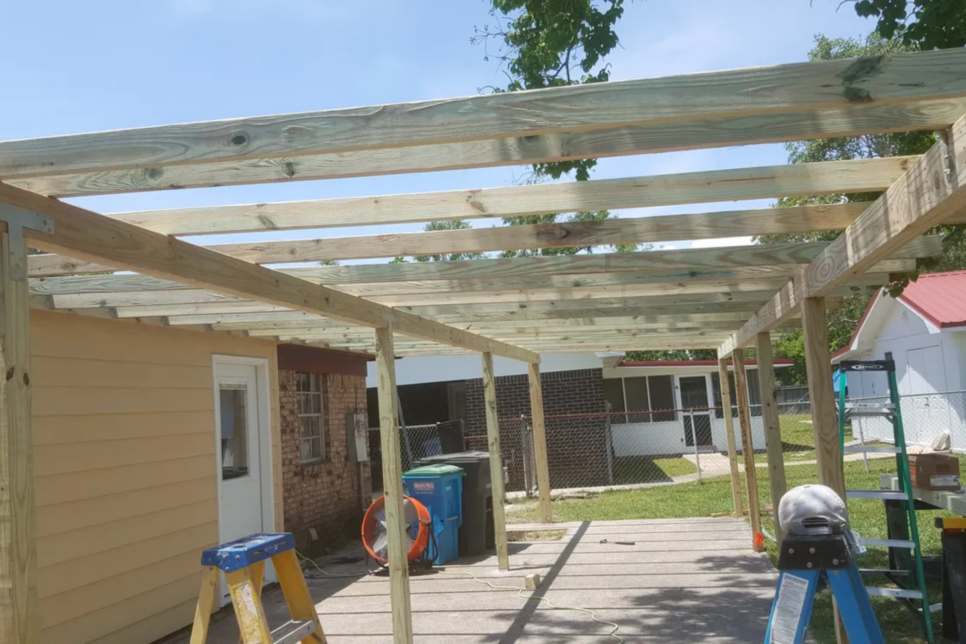 Wooden deck under construction; building frame with vertical and horizontal beams.