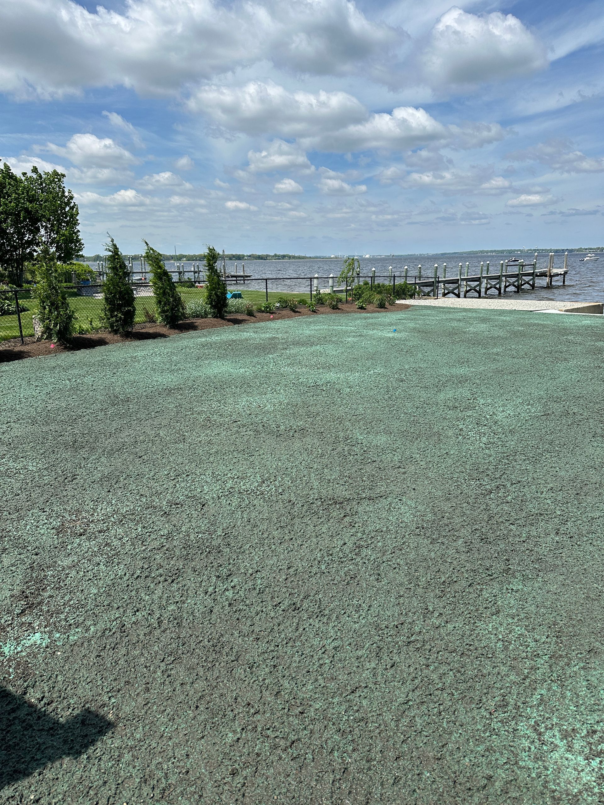 A large grassy field with a dock in the background.