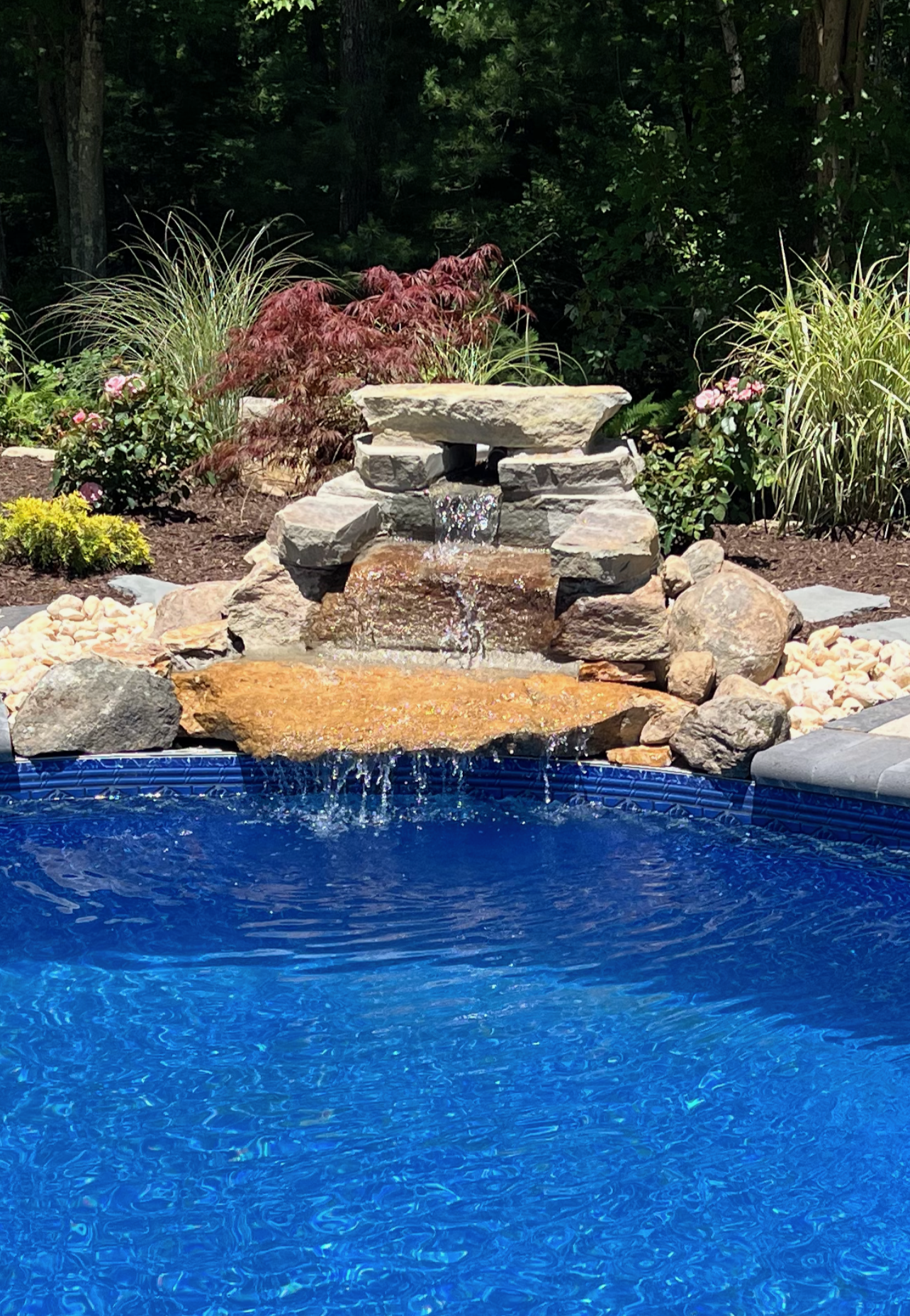 There is a waterfall in the middle of the pool.