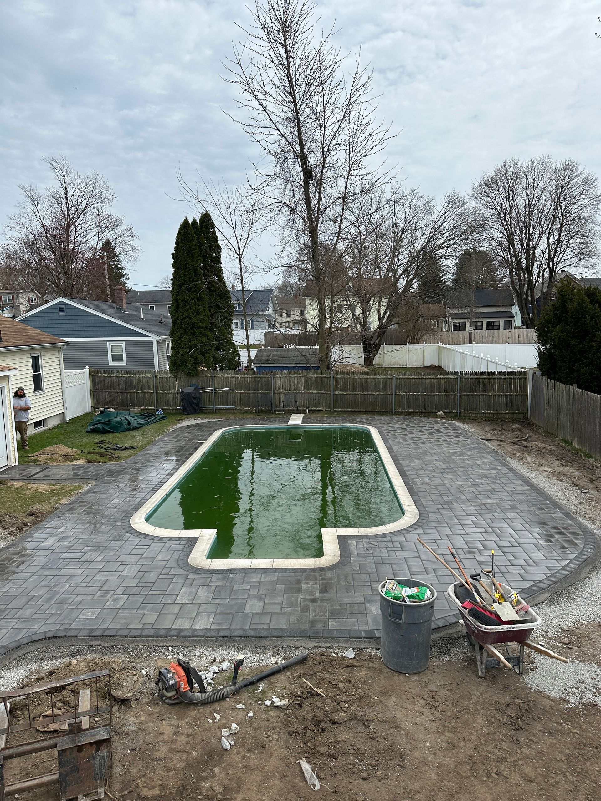 A swimming pool is being built in the backyard of a house.