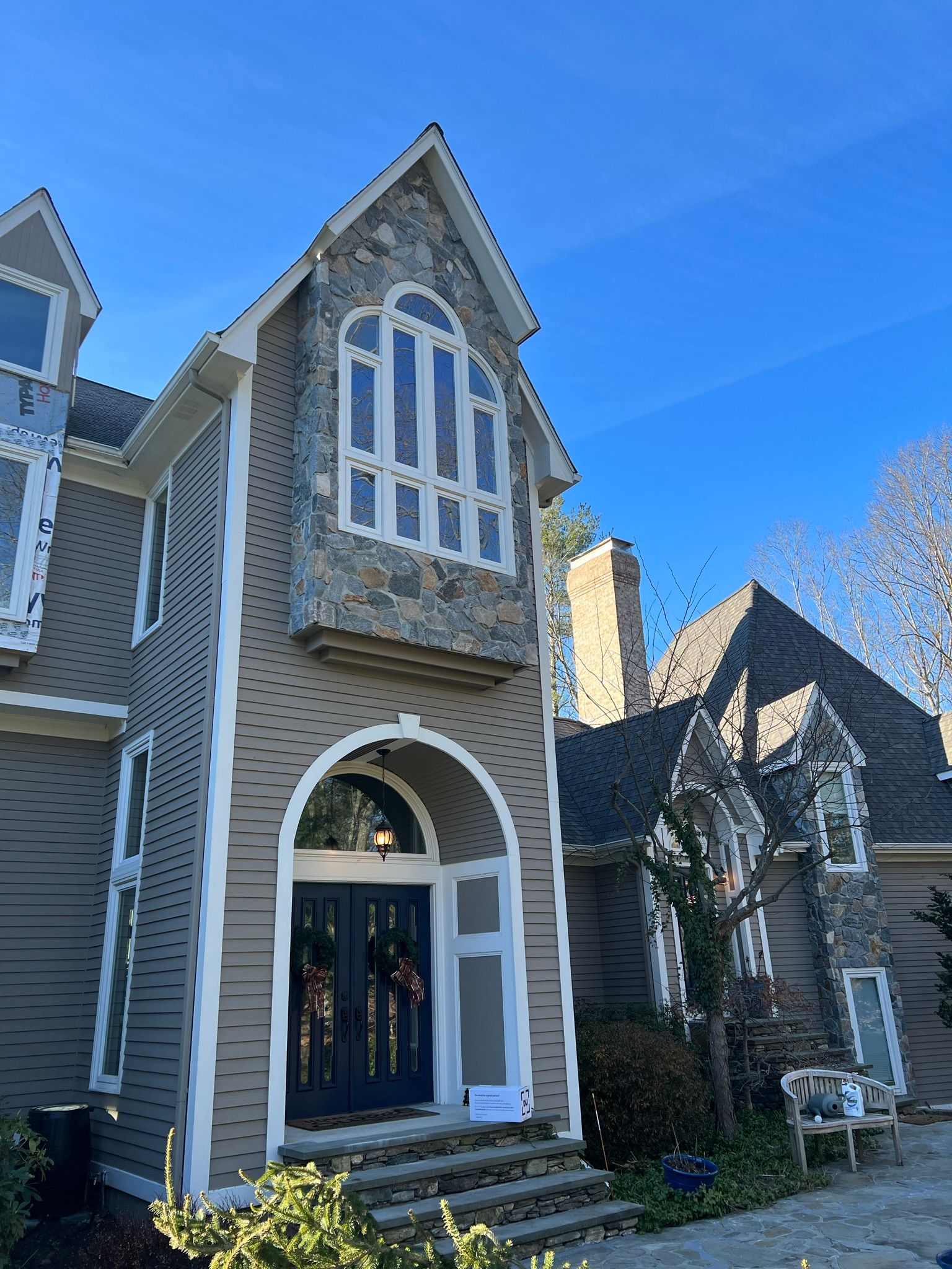 A large house with a lot of windows and a blue sky in the background.
