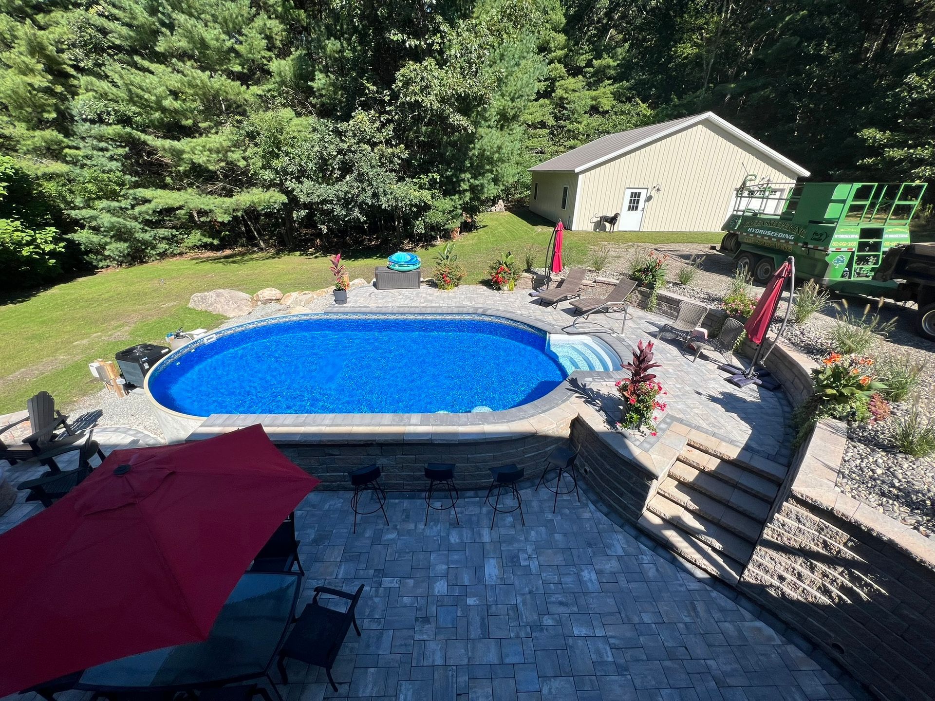 An aerial view of a swimming pool in a backyard surrounded by trees.