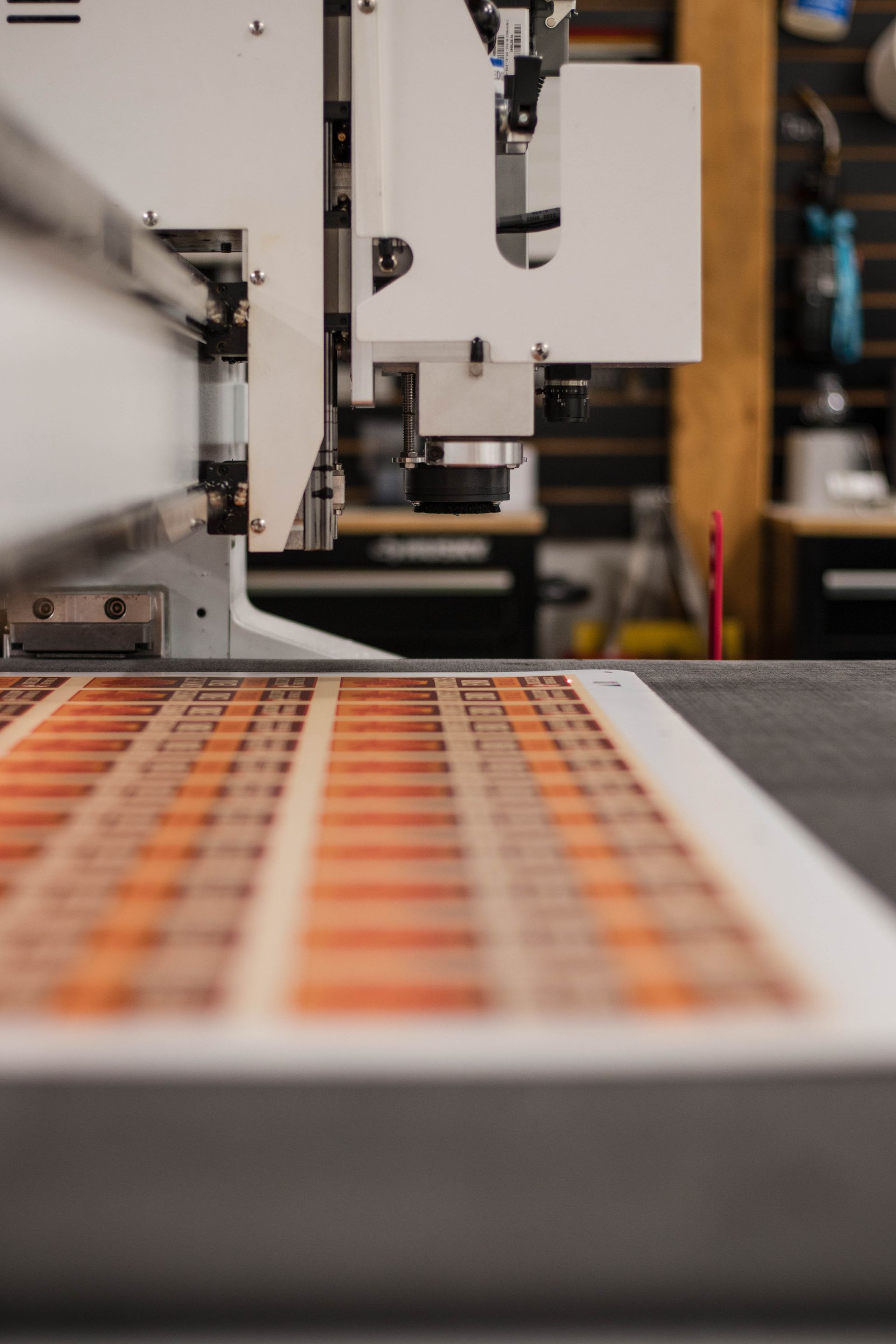 Industrial machine working over an orange conveyor belt in a factory setting