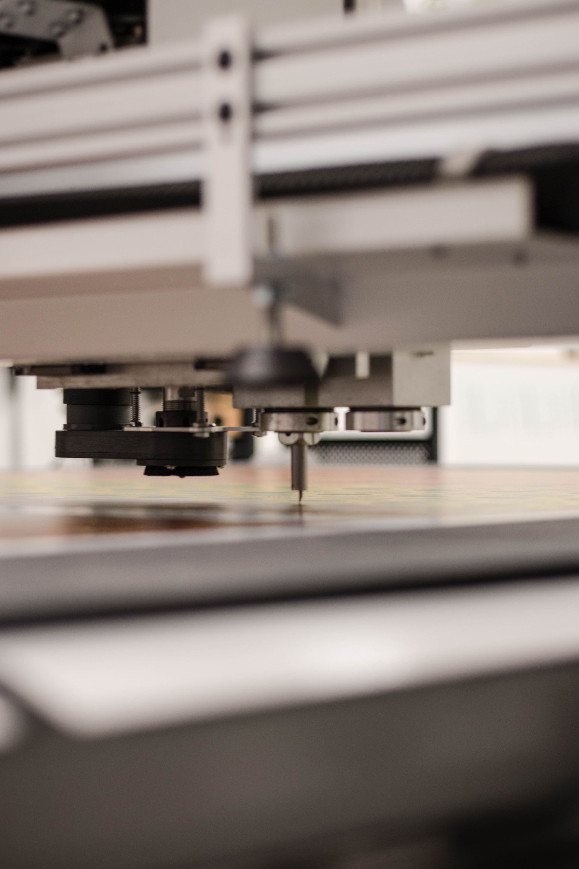 Close-up of a 3D printer nozzle and print bed in a workshop