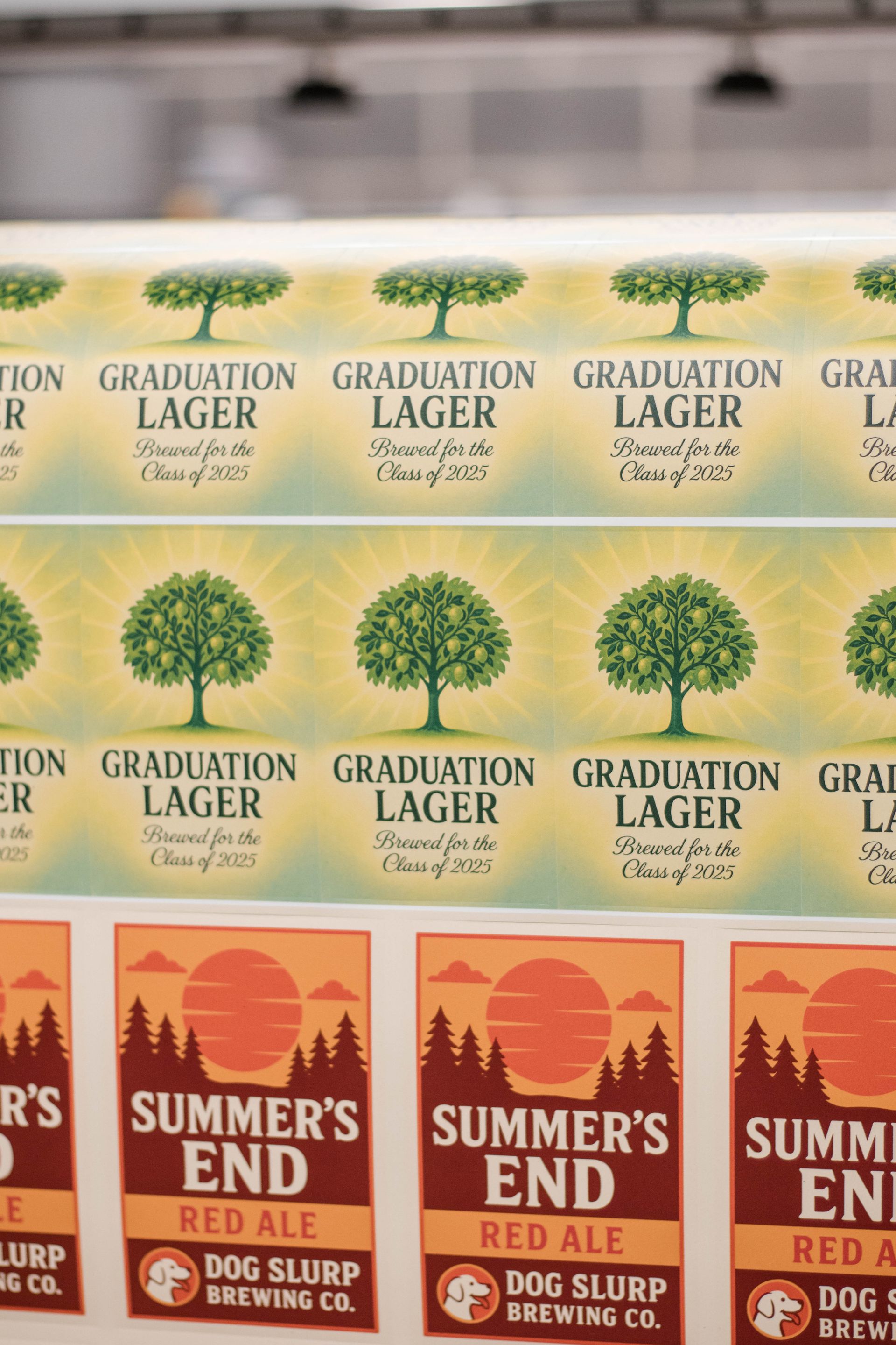 Stacked beer cases with labels for Graduation Lager and Summer's End Red Ale.