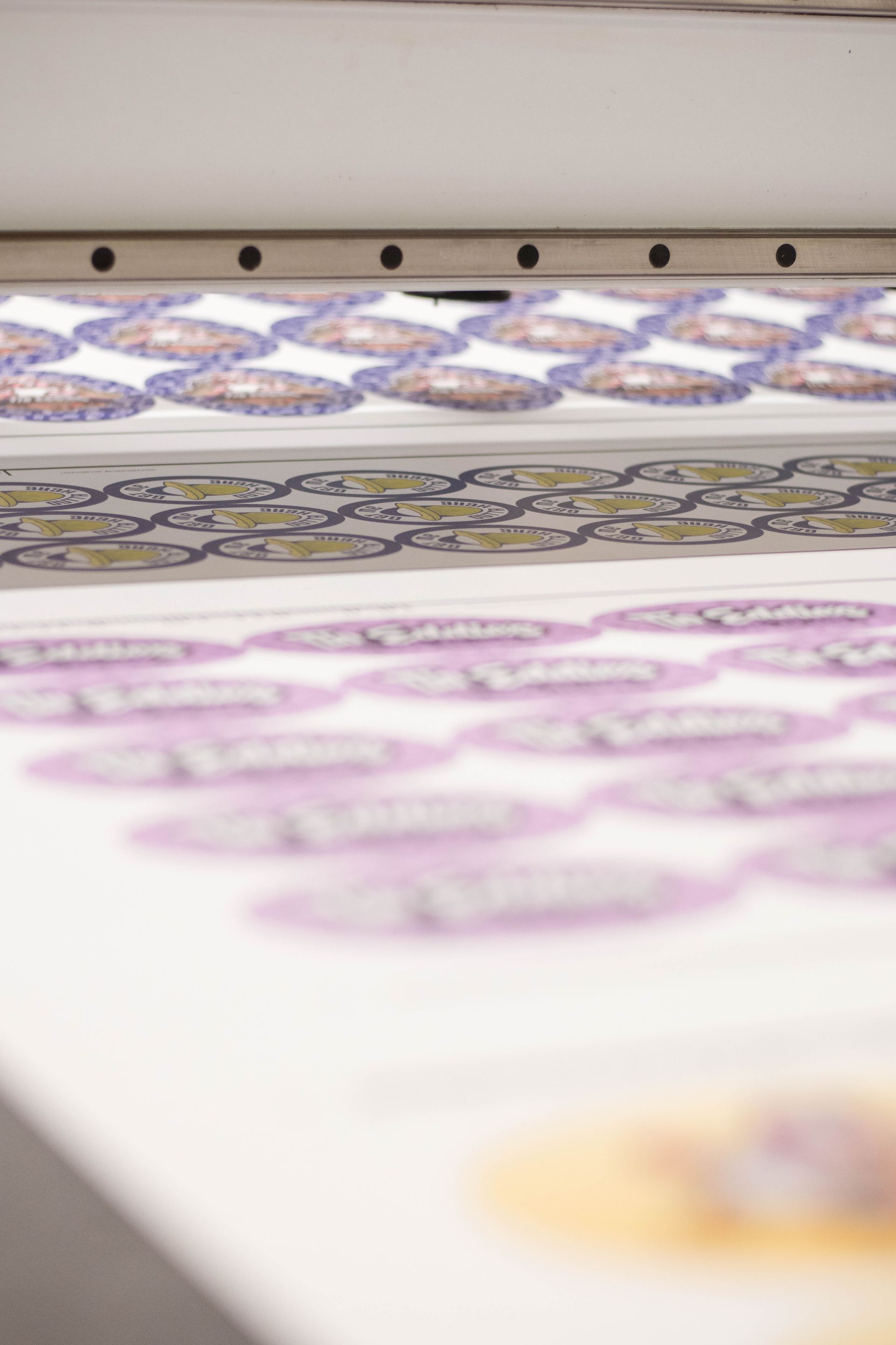 Rows of colorful patterned fabric laid out on a printing machine conveyor