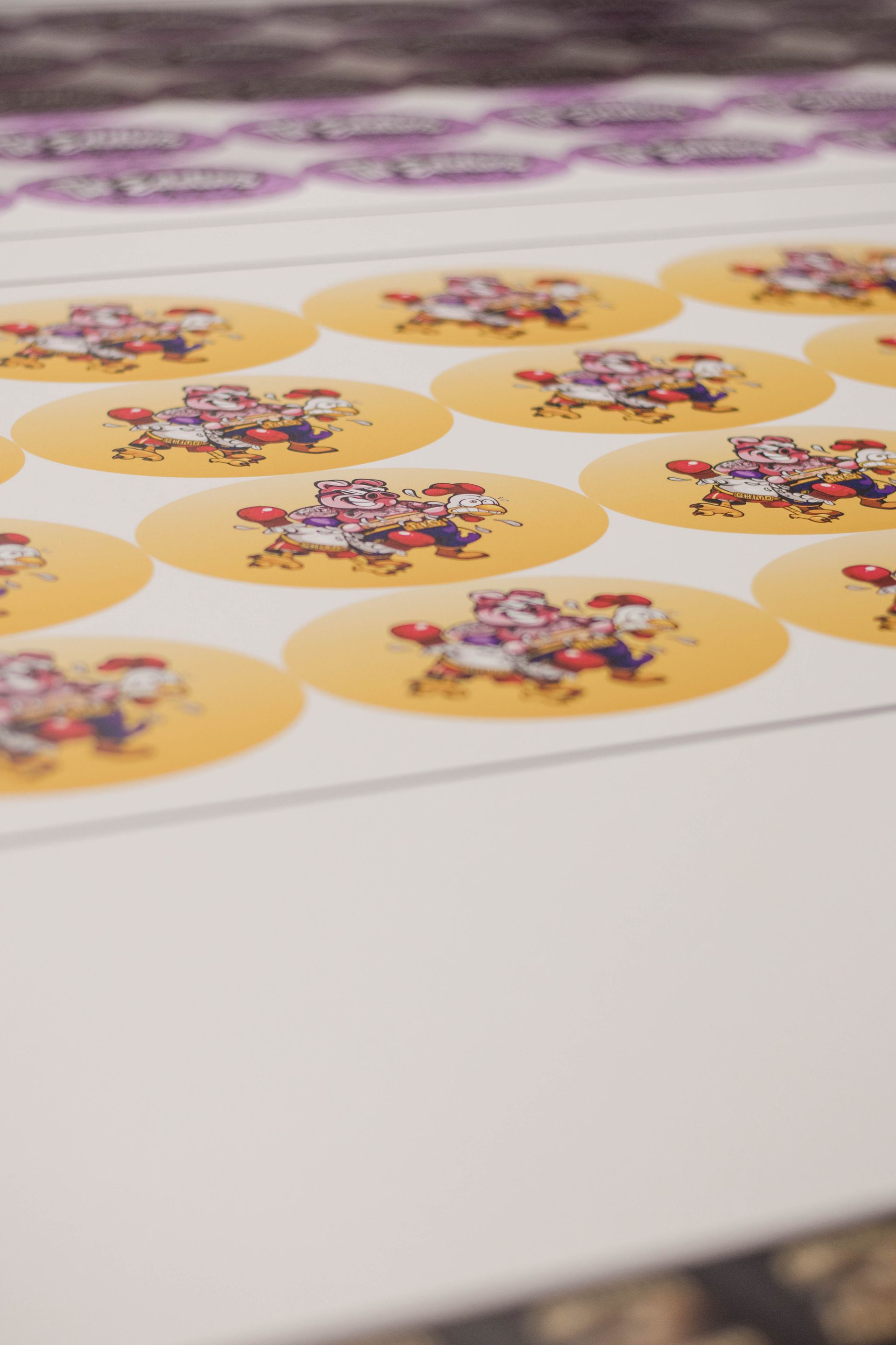 Sheet of colorful circular sticker labels with a floral design, laid out on a white surface.