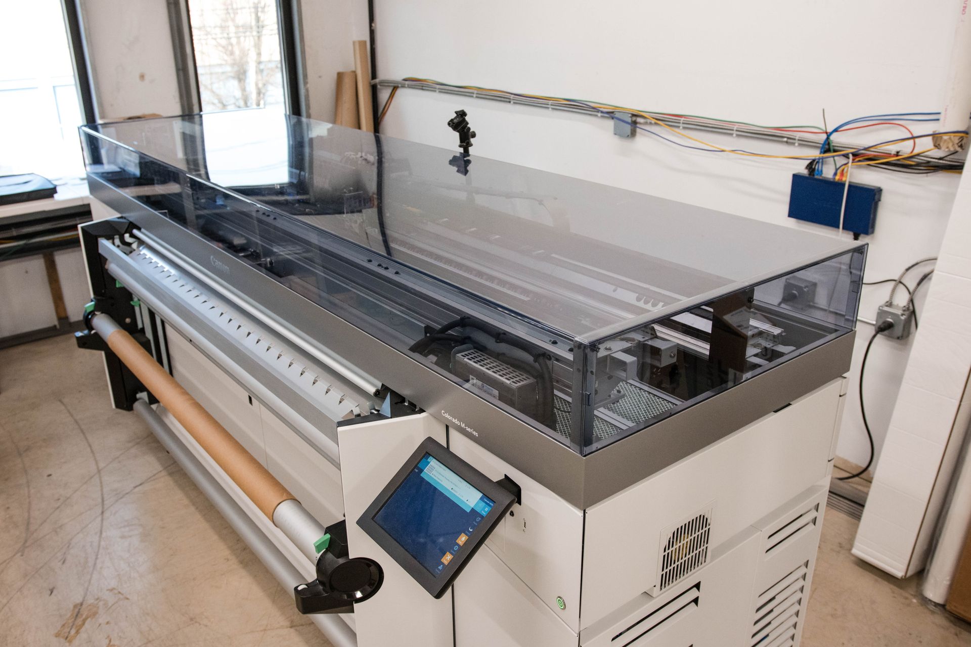 Large industrial laser cutter with a touchscreen control panel in a workshop
