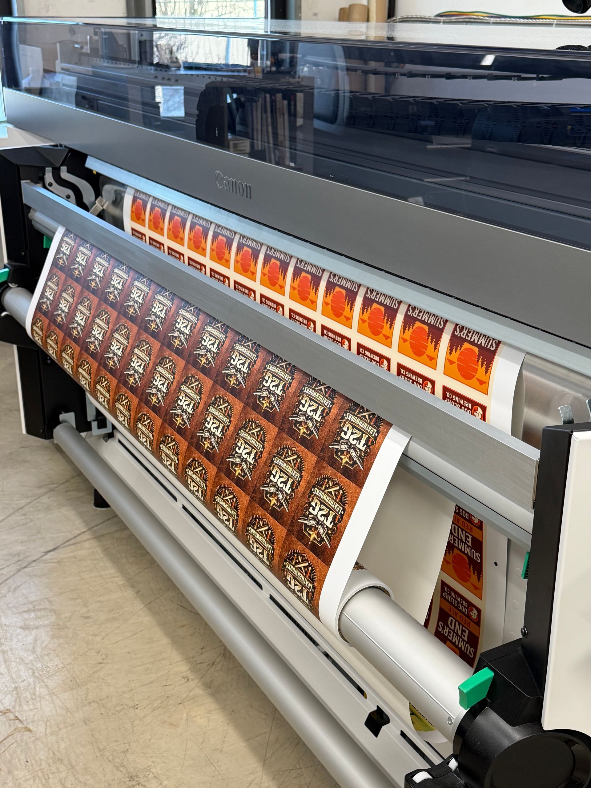 Large-format printing machine producing colorful labels in a print shop