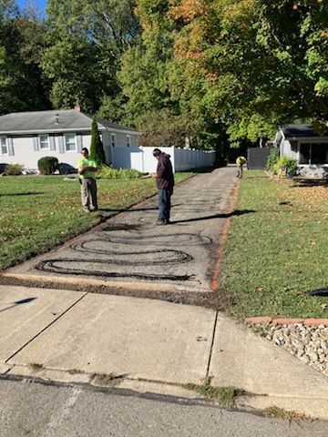 People preparing asphalt driveway for repair - before